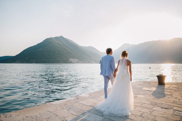 honeymoon wedding couple travel sea side. Back view. Mountains and sea background in Montenegro